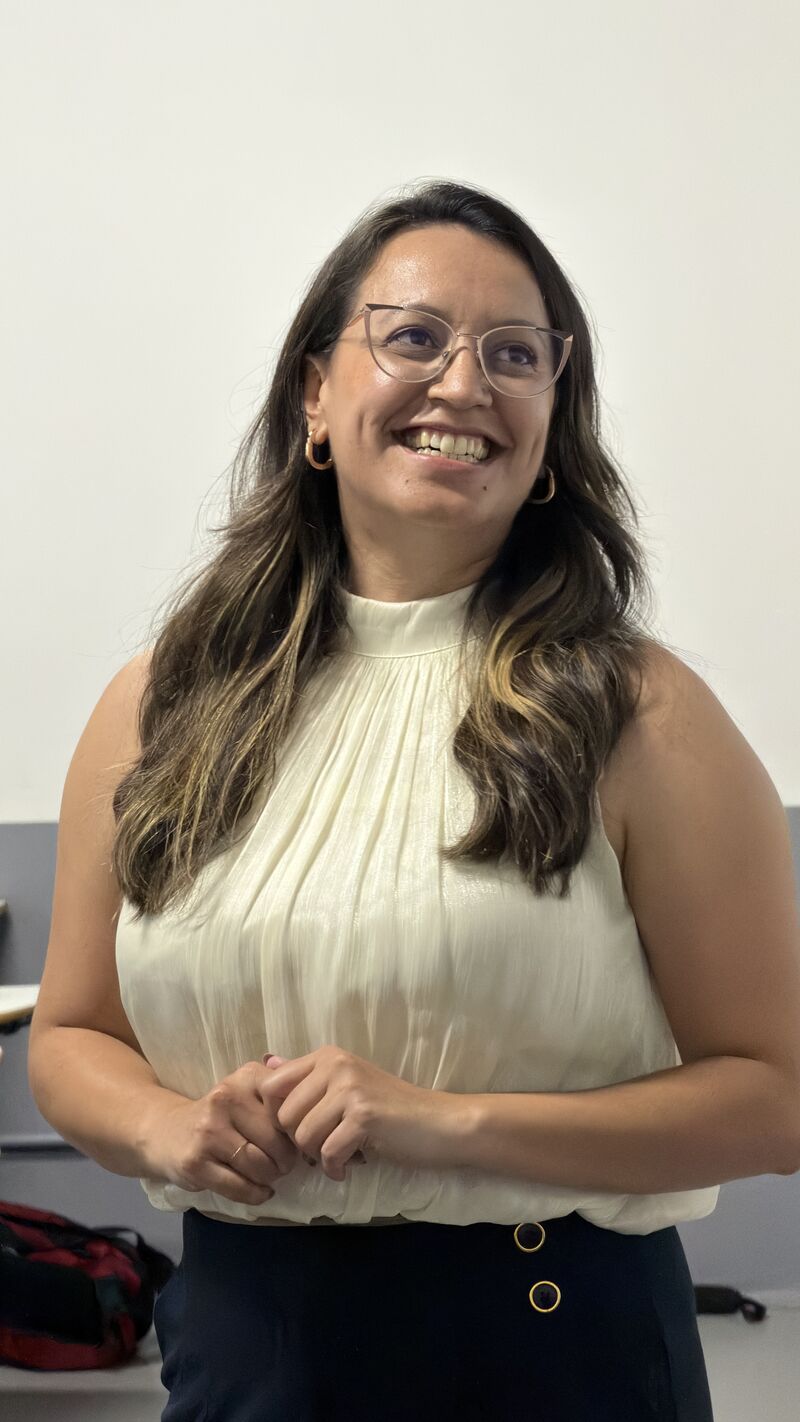 Amanda Moura sorrindo durante a palestra