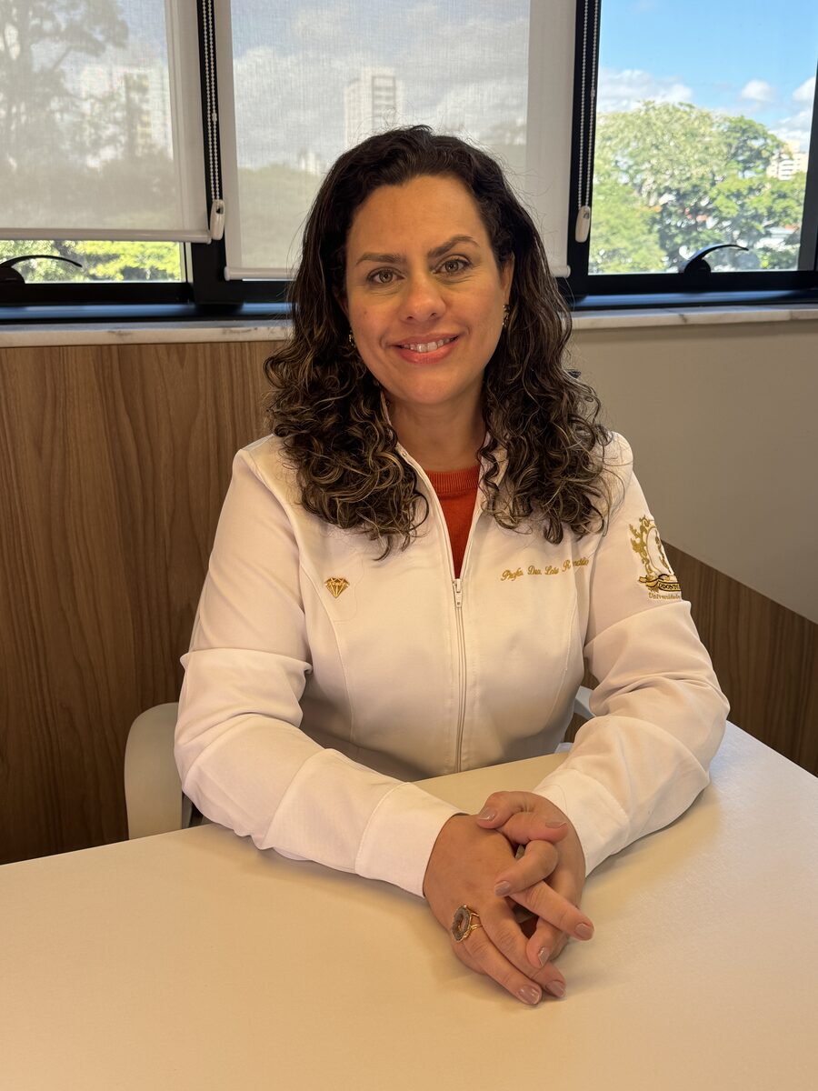 Dra. Laís Concílio sorrindo, sentada no consultório